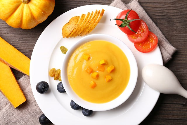 Pumpkin puree in a white bowl with a spoon balanced on the edge