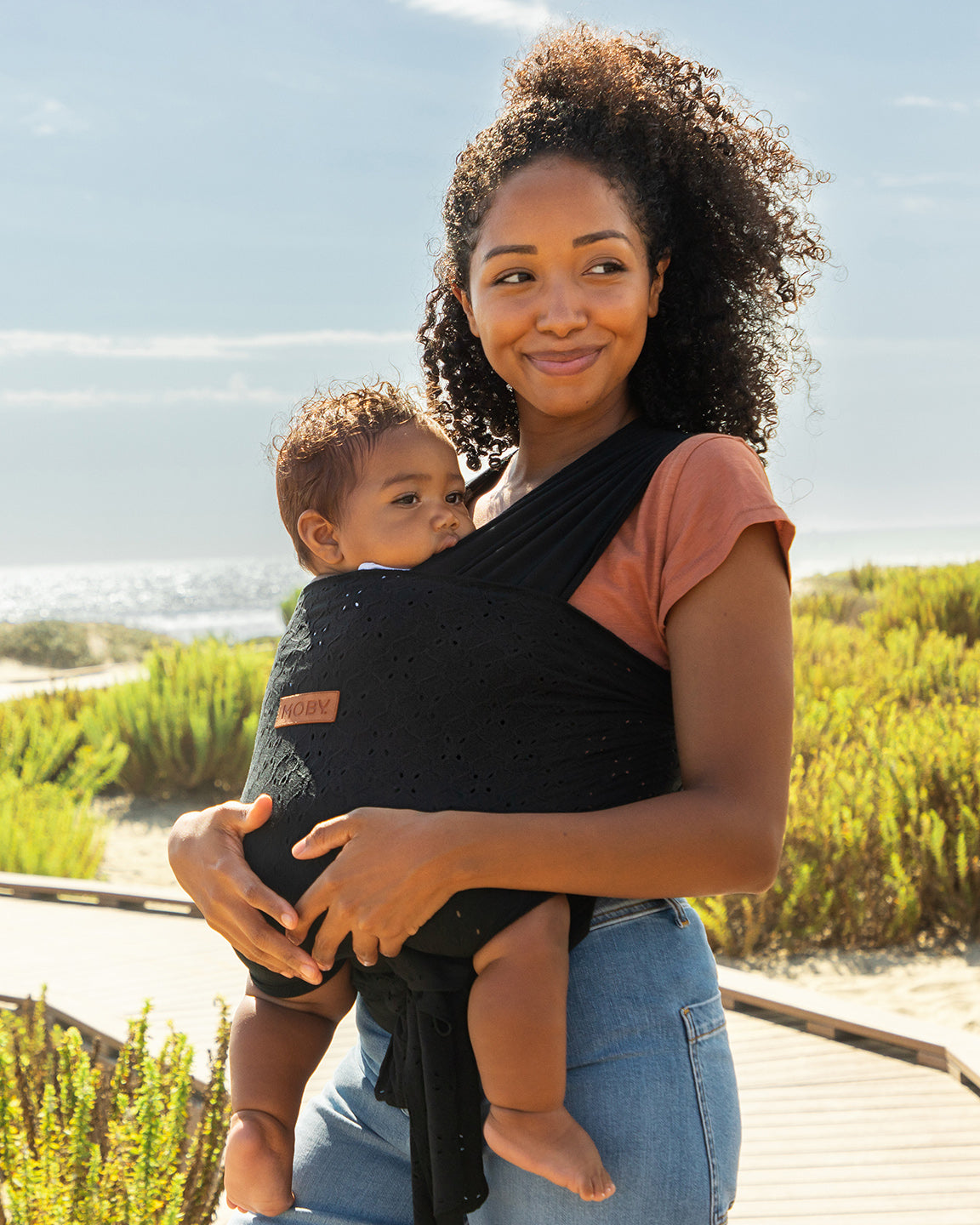 mom wearing baby in easy wrap in black eyelet