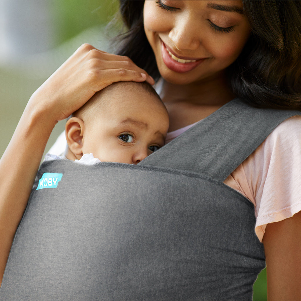 mom wearing baby in elements wrap in asphalt