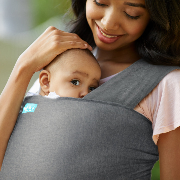 mom wearing baby in elements wrap in asphalt