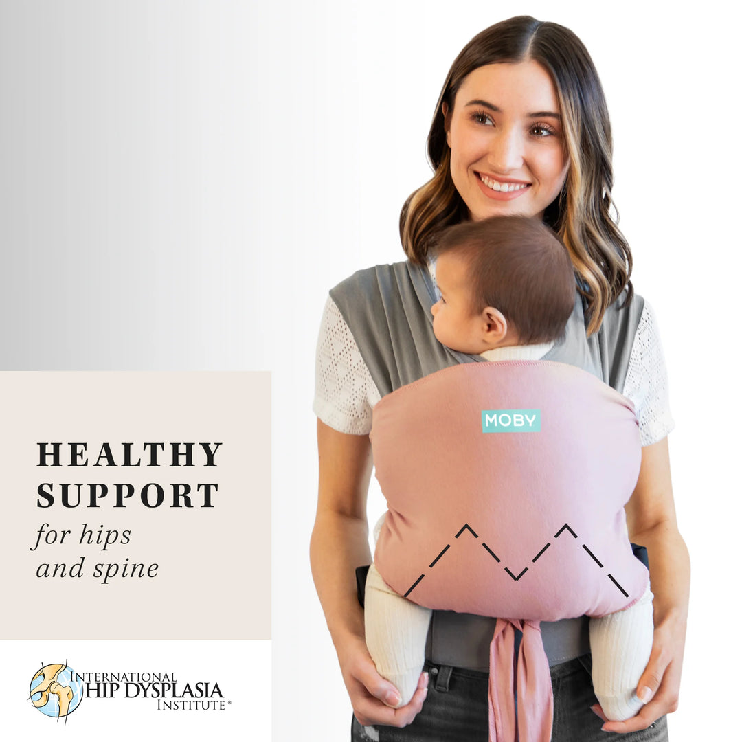 mom wearing baby in easy wrap in dusty rose. healthy support for hips and spine from the international hip dysplasia institute.