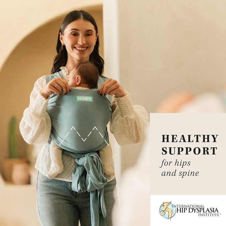 mom wearing evolution wrap in sea glass. healthy support for hips and spine from the international hip dysplasia institute.
