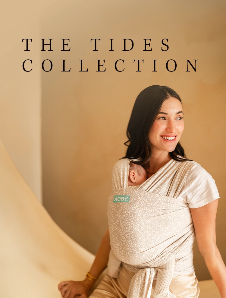 the tides collection featuring mom wearing newborn baby in coastal blooms beige moby wrap