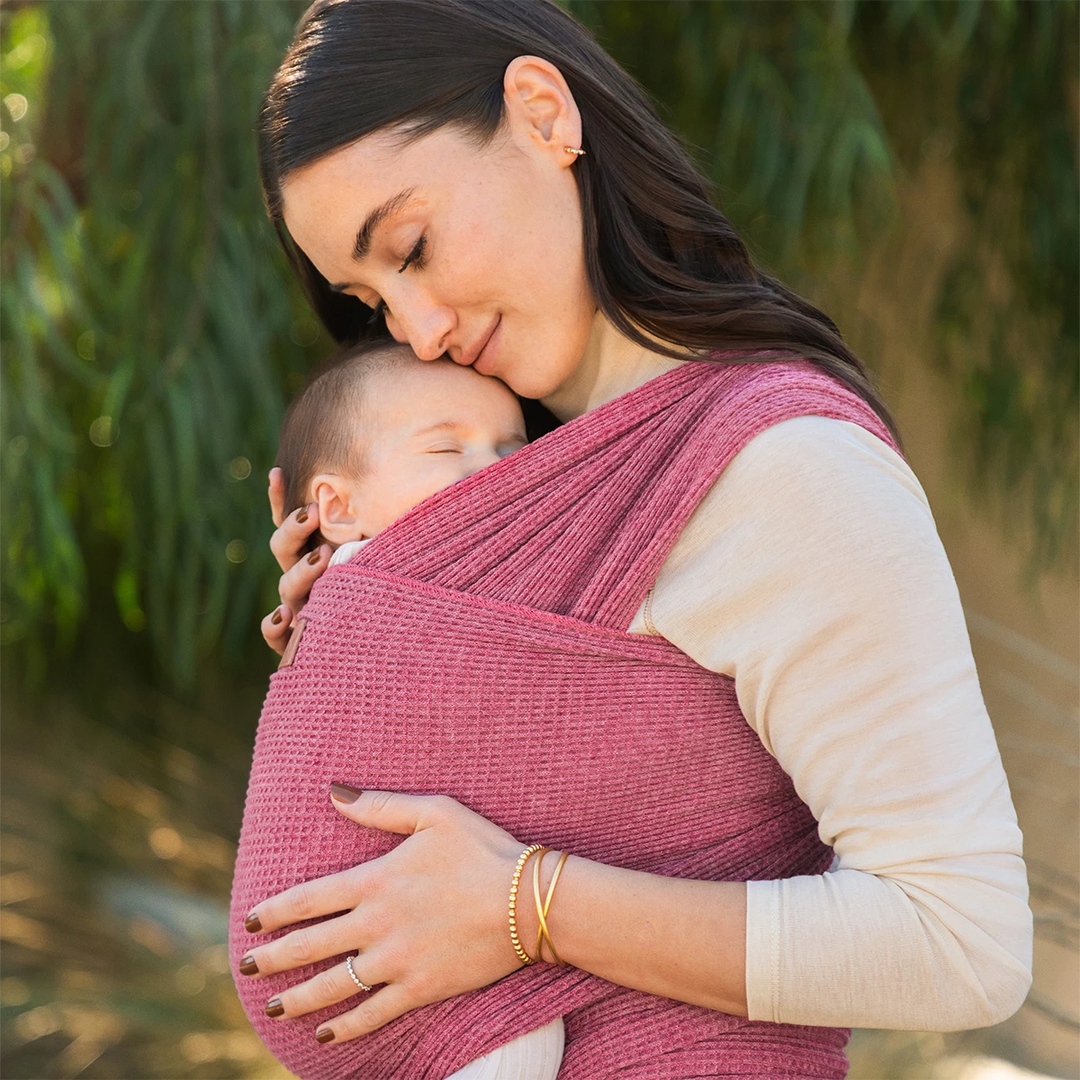 mom wearing baby in waffle knit wrap in desert rose