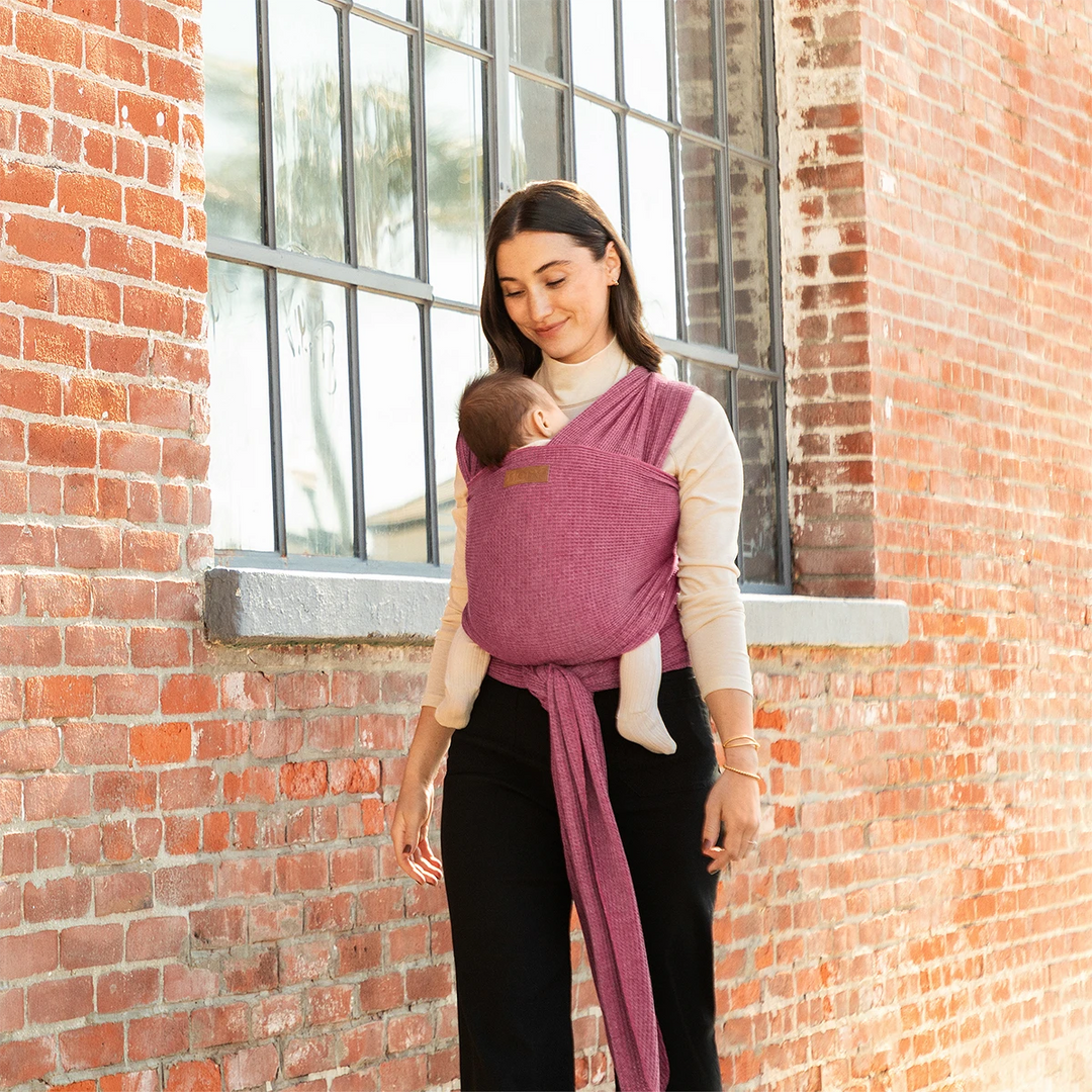 mom wearing baby in waffle knit wrap in desert rose