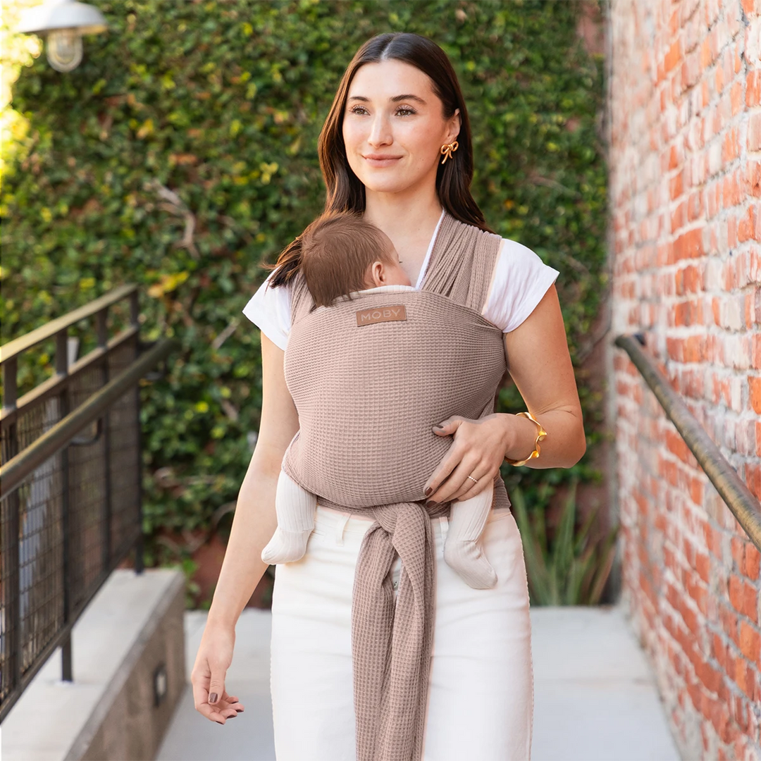 mom wearing baby in waffle knit wrap in sandstone