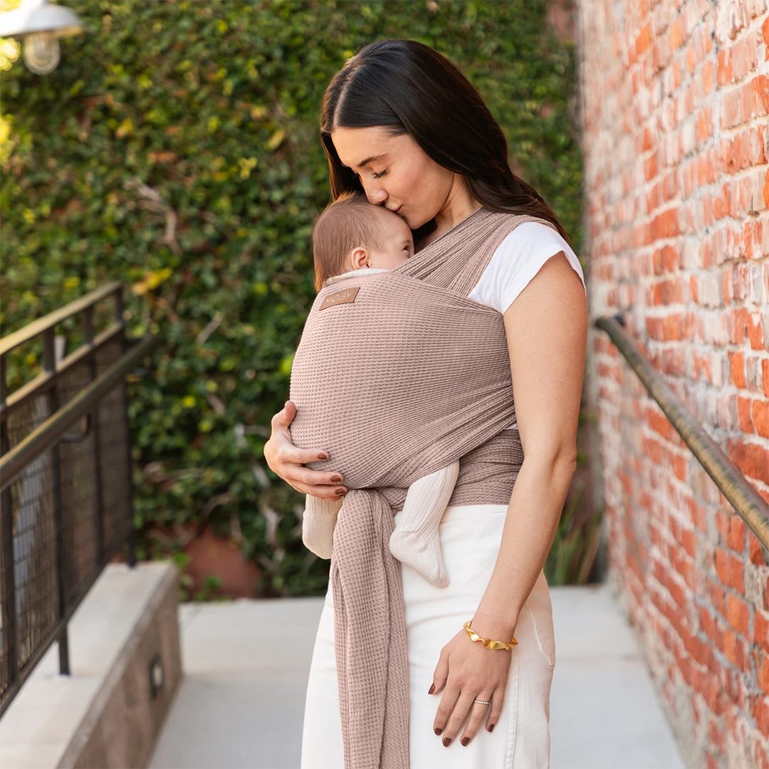 mom wearing baby in waffle knit wrap in sandstone