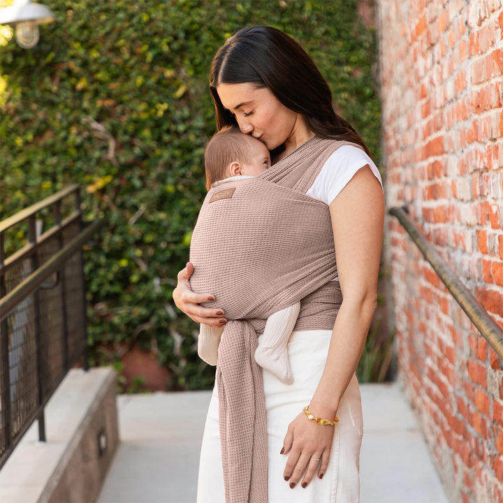mom wearing baby in waffle knit wrap in sandstone
