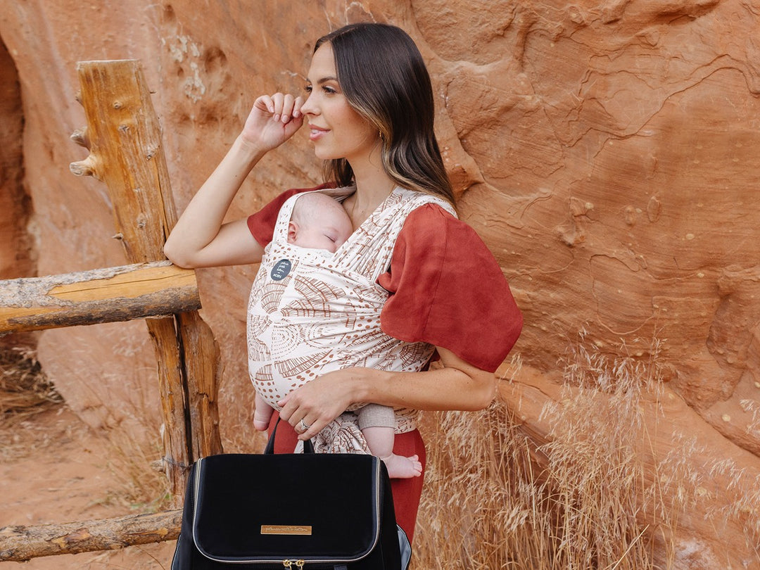 Mother wearing baby in a MOBY wrap, carrying a diaper bag