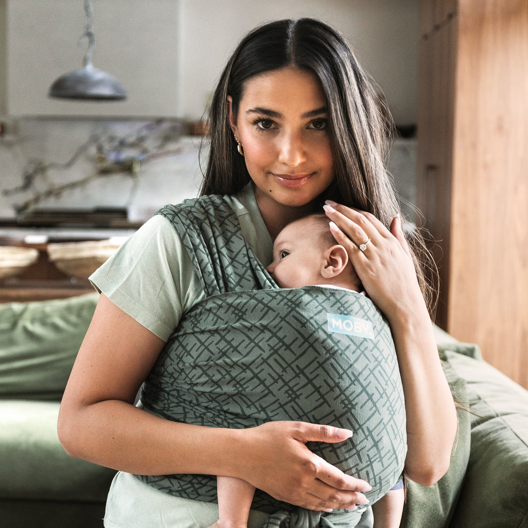 mother wearing baby in olive green printed baby wrap carrier wearing