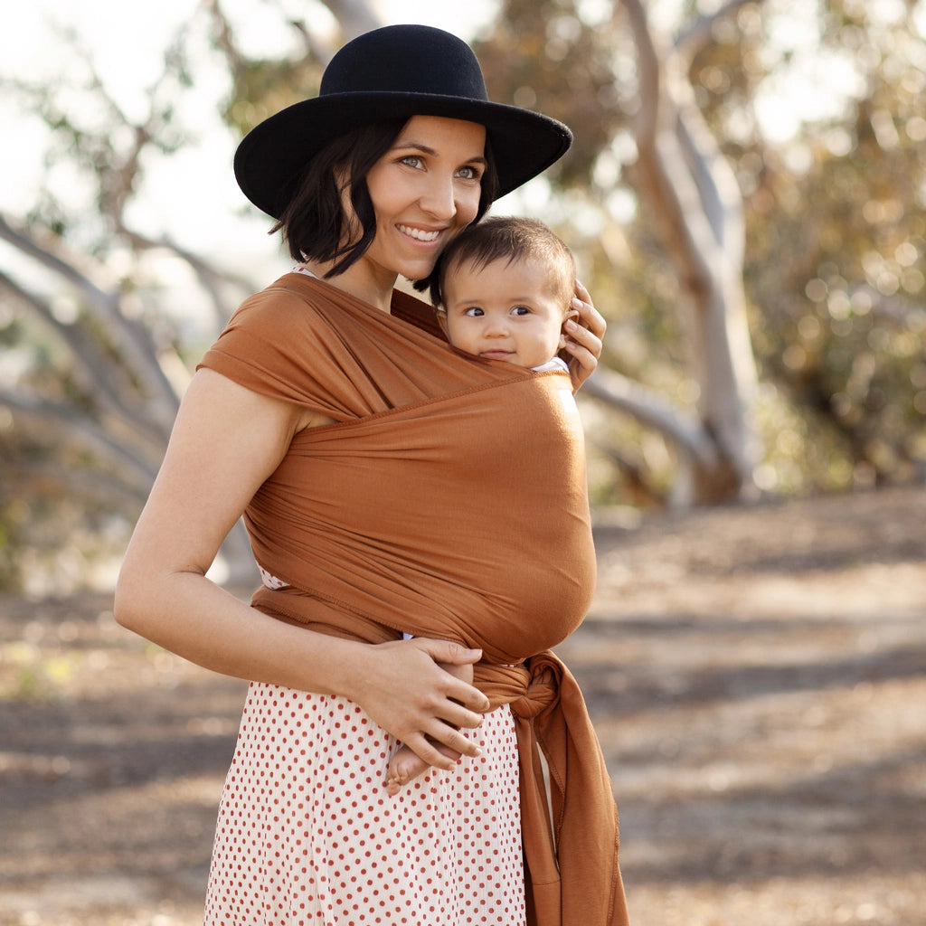 moby wrap caramel shown on mom wearing 4 month old baby