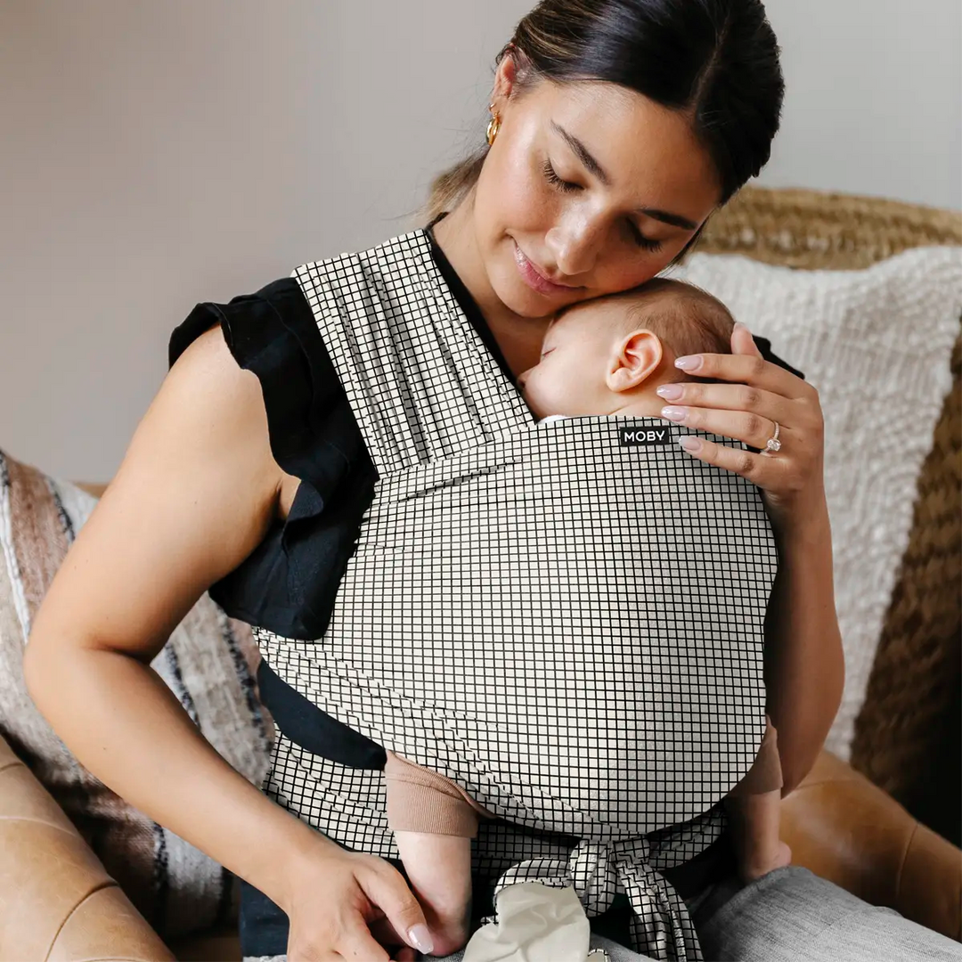 mom wearing baby in classic wrap in prairie check