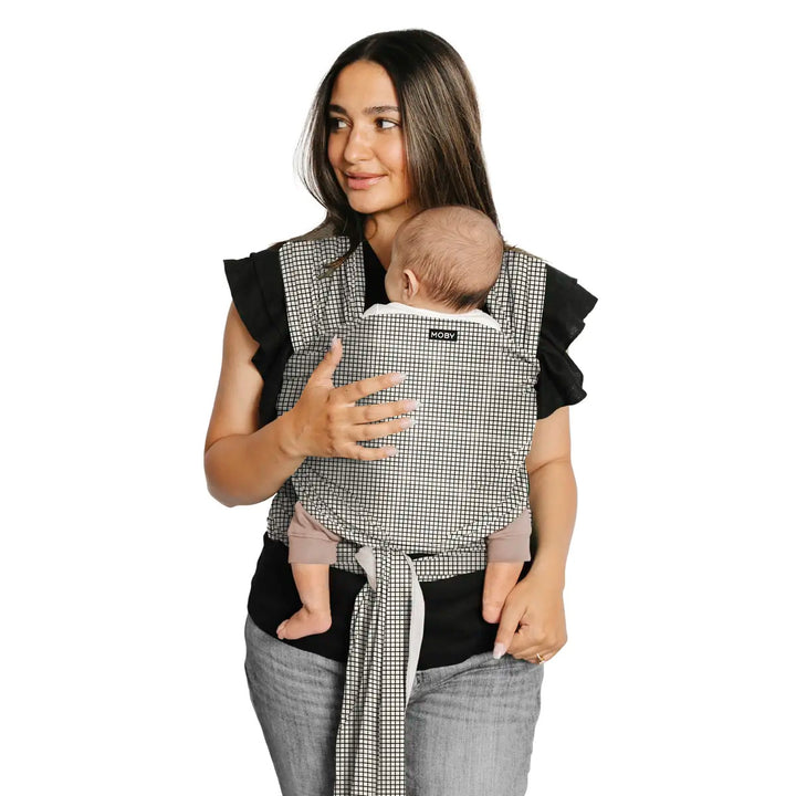 mom wearing baby in classic wrap in prairie check