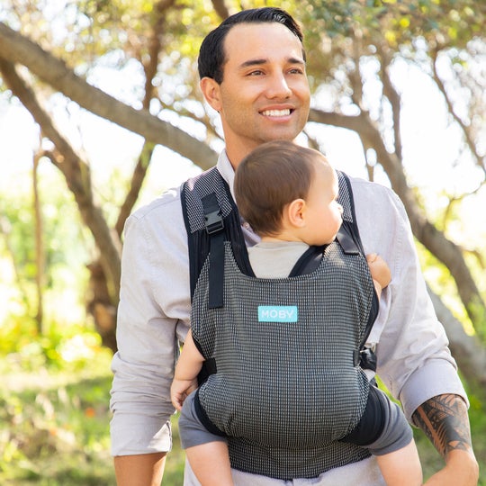 Dad in button down shirt carrying baby in a moby wrap