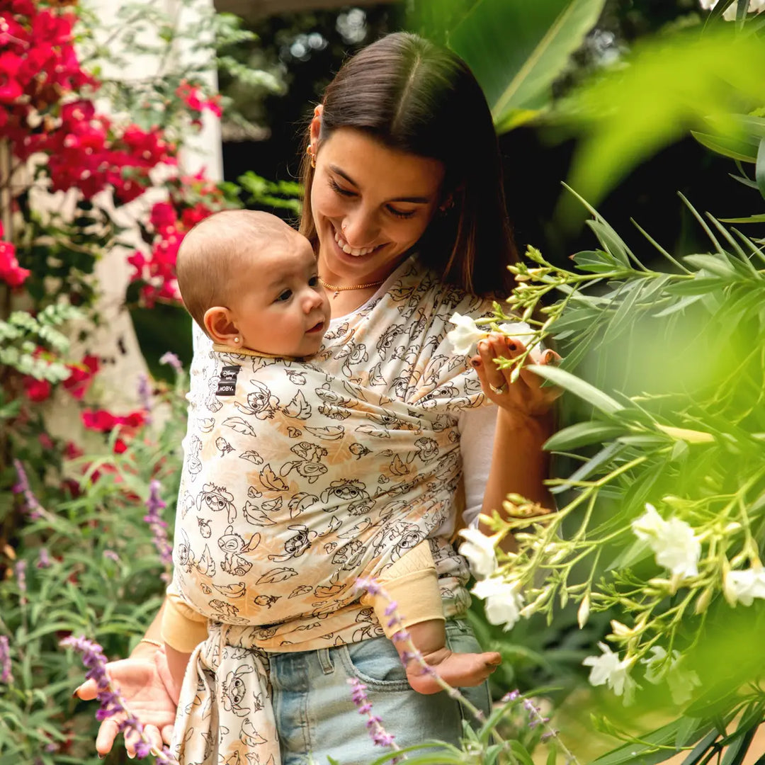 mom wearing baby in moby featherknit wrap in disney's aloha stitch