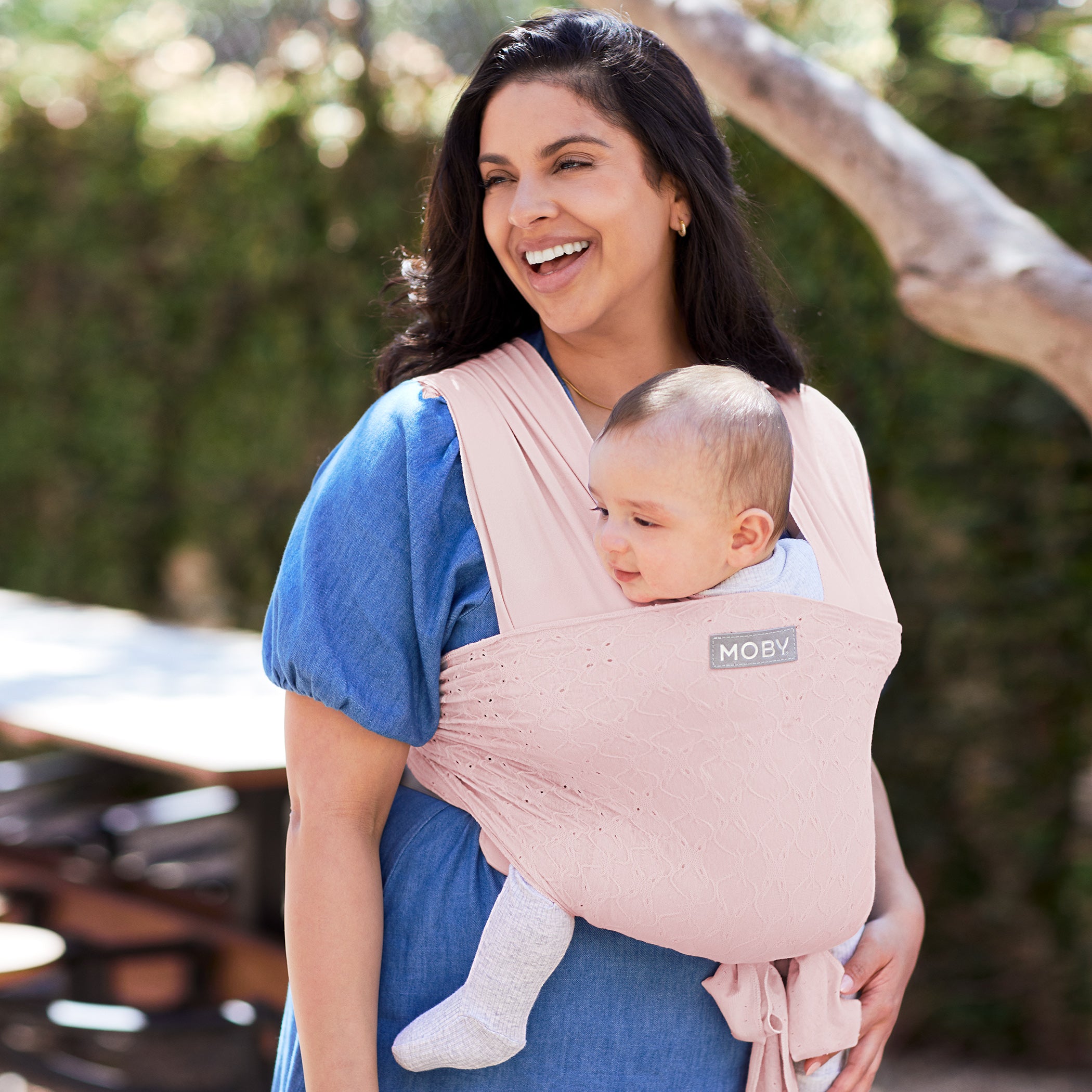 mom wearing baby in MOBY Easy Wrap Carrier by Petunia Pickle Bottom in Rose Quartz Eyelet