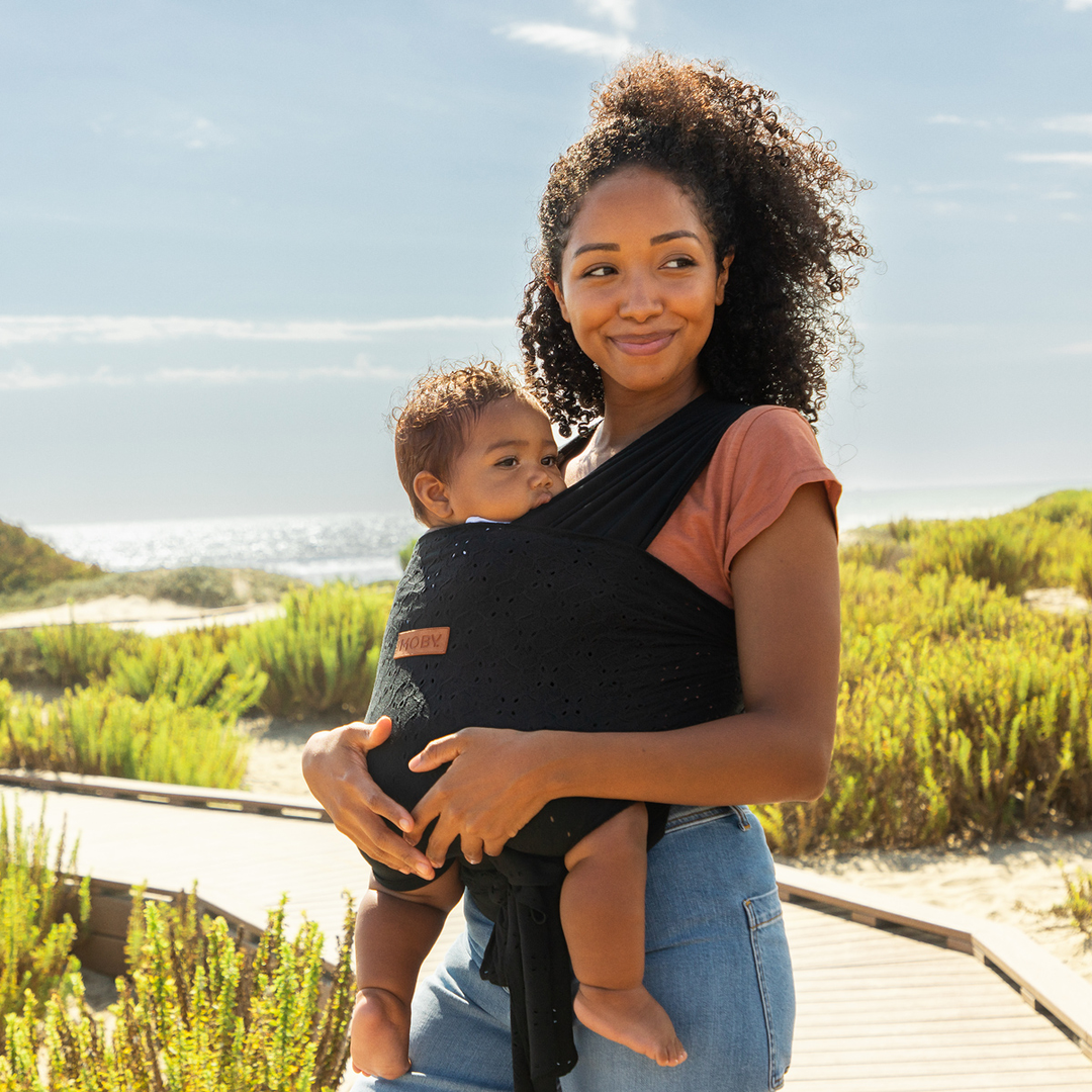 mom wearing baby in moby easy wrap in black eyelet