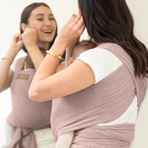 mom wearing baby in waffle knit baby wrap in sand