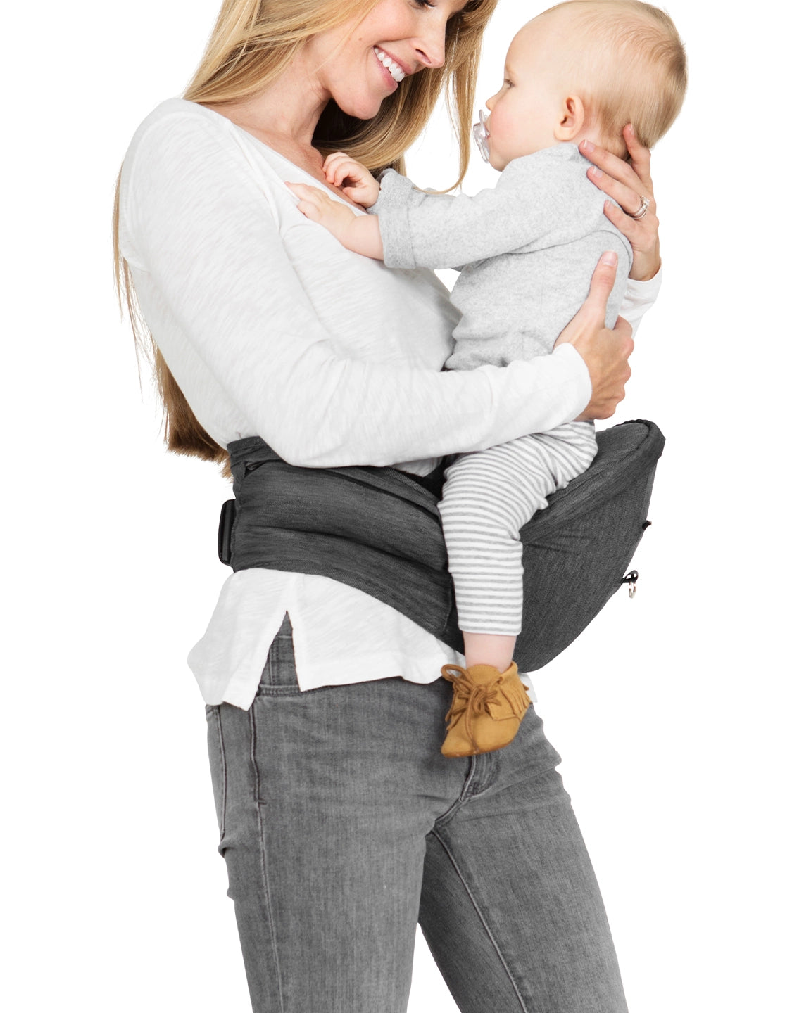 mom holding baby while wearing the hip seat carrier