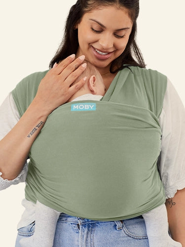 plus size mom wearing green baby wrap carrier