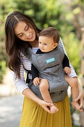 woman in mustard dress wearing her baby in a moby wrap