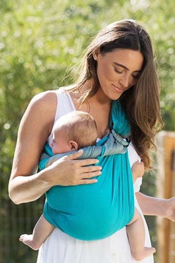 woman in tank top wearing her baby in a moby wrap