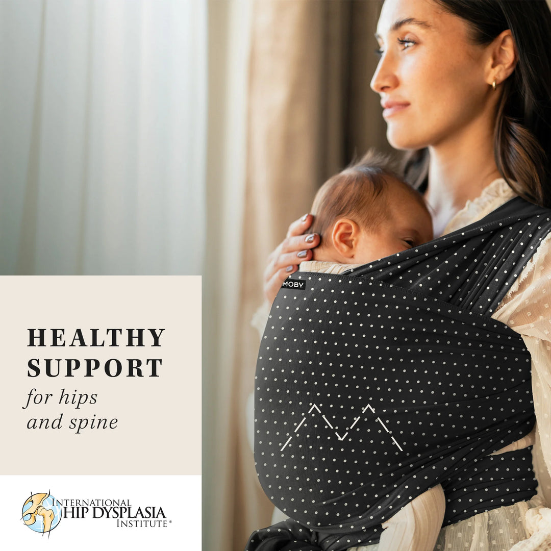 mom wearing baby in Classic Wrap Baby Carrier in Midnight Speckle. healthy support for hips and spine from the international hip dysplasia institute.