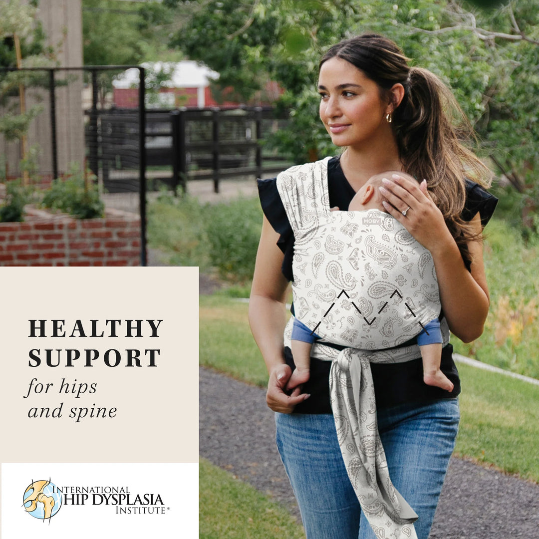 Mom wearing baby in Classic Wrap Baby Carrier in Bandana. healthy support for hips and spine by international hip dysplasia institute