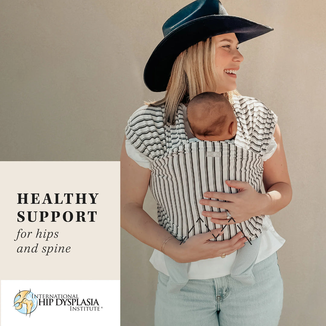 mom wearing baby in Classic Wrap Baby Carrier in Heirloom Stripe. healthy support for hips and spine by international hip dysplasia institute