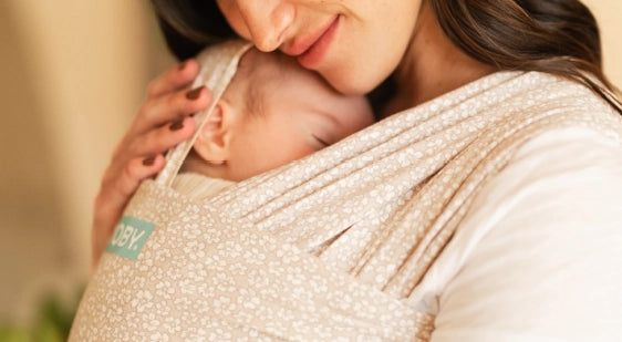 mom caressing her baby while wearing the classic wrap in coastal blooms