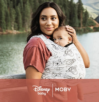 disney baby and moby. mom wearing baby in featherknit wrap in winnie the pooh and pals
