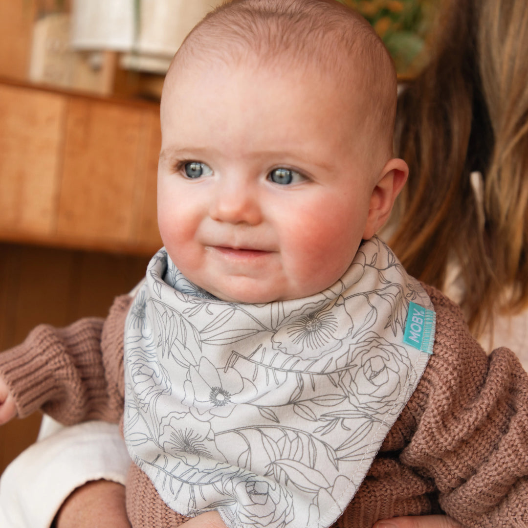 baby wearing reversible bib set in the pattern seaside poppies