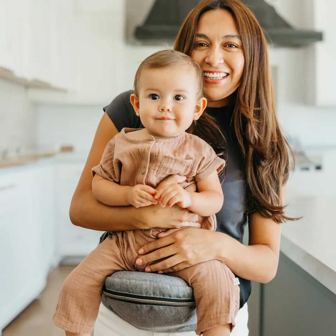 mom wearing baby in hip seat in heather grey