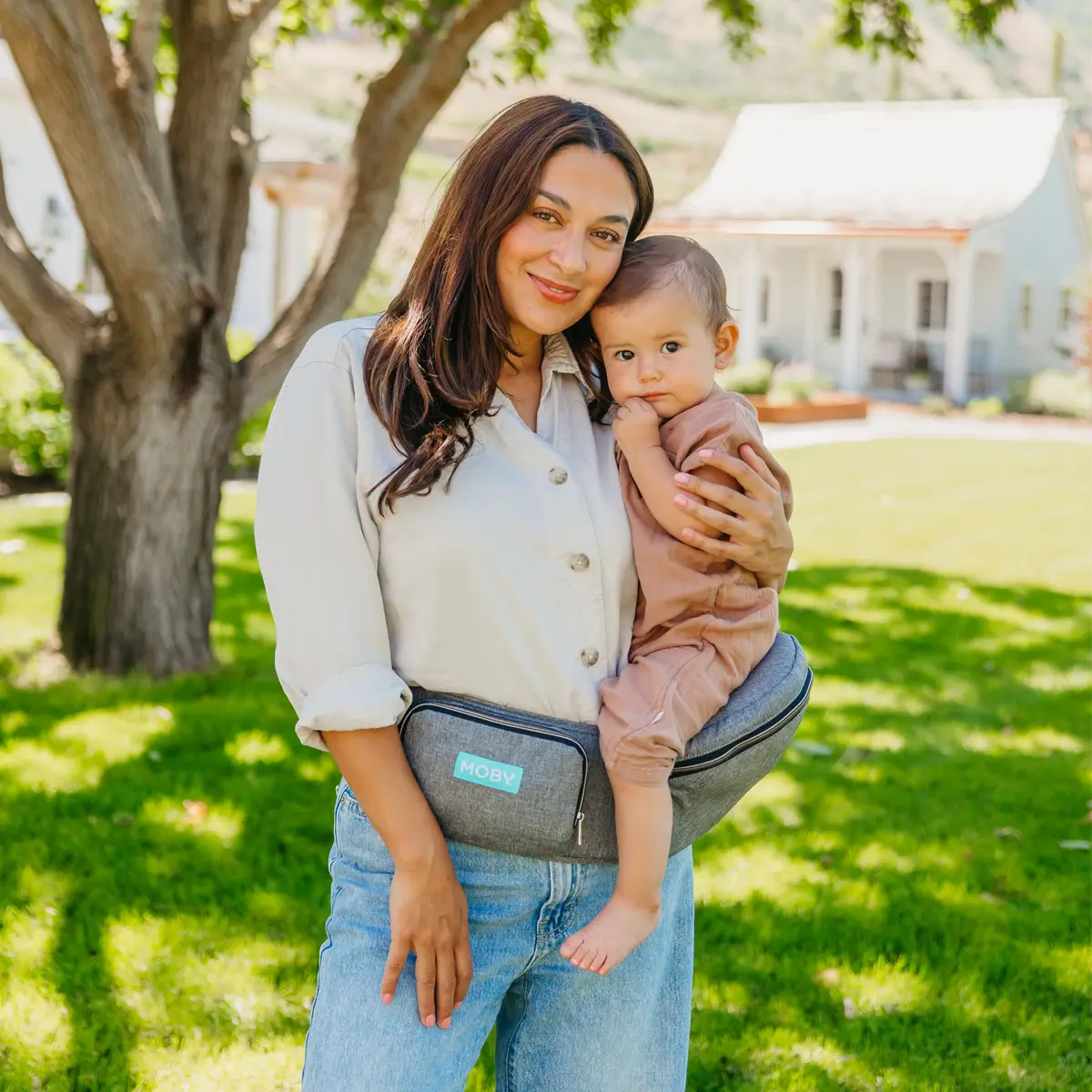 mom wearing baby in hip seat in heather gray