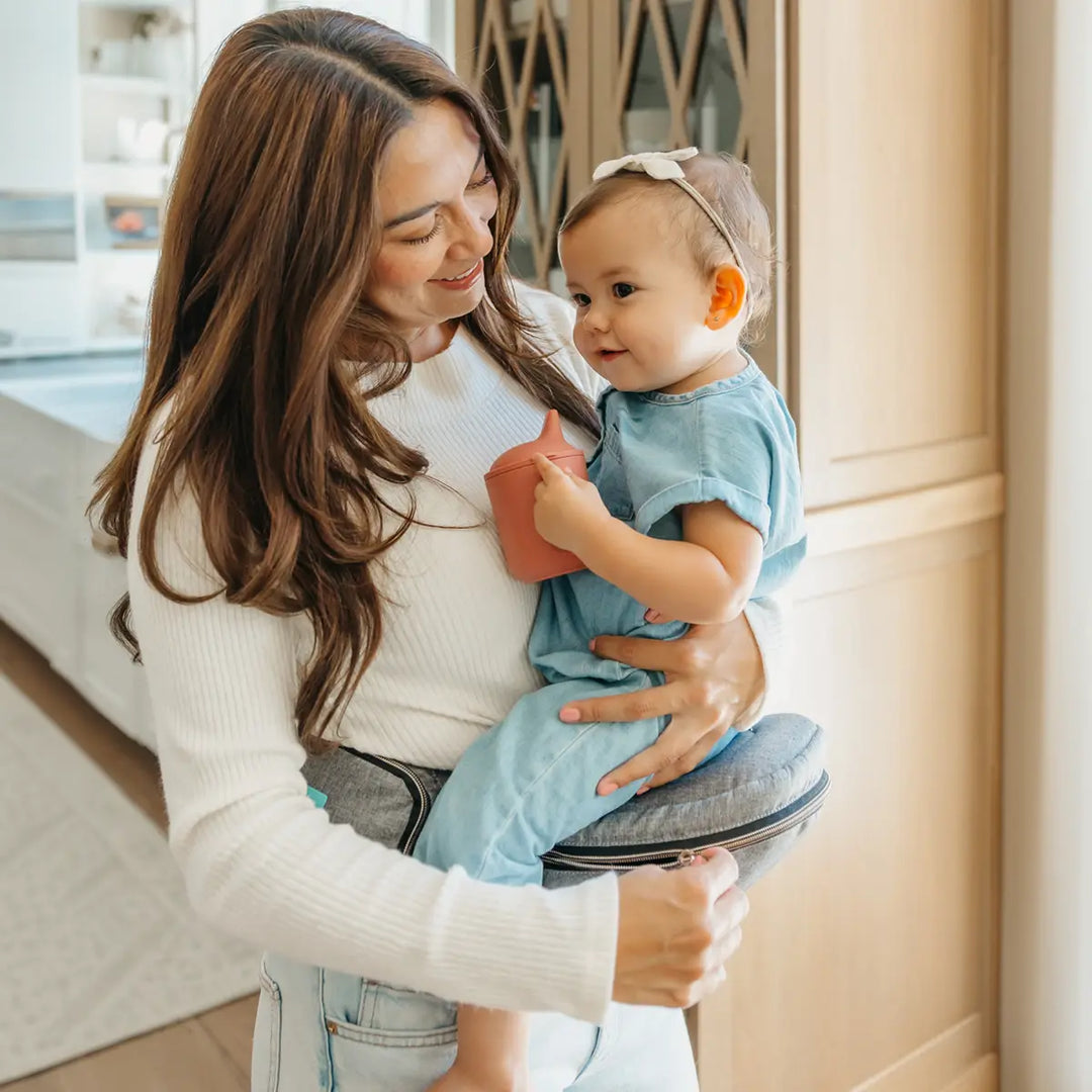 mom wearing baby in hip seat in heather gray