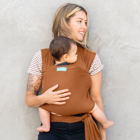 Mom wearing brown moby wrap and baby