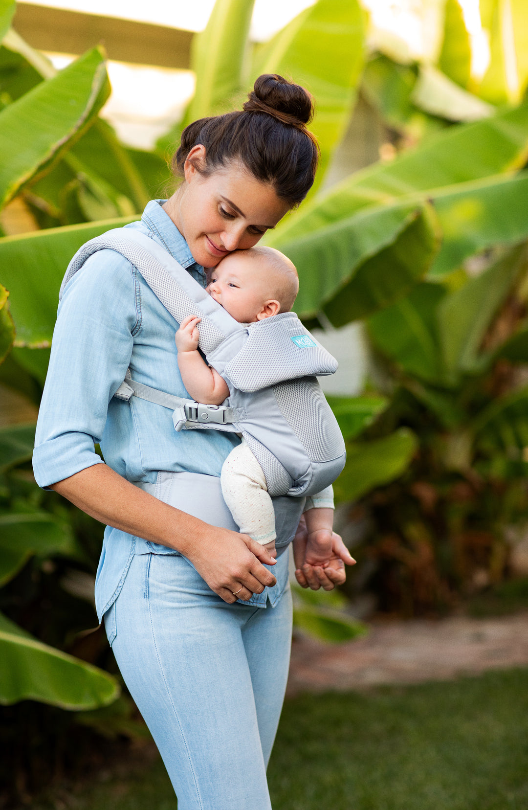 Mom in blue shirt holding baby in moby wrap