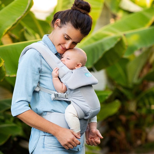 Mom in blue shirt holding baby in moby wrap