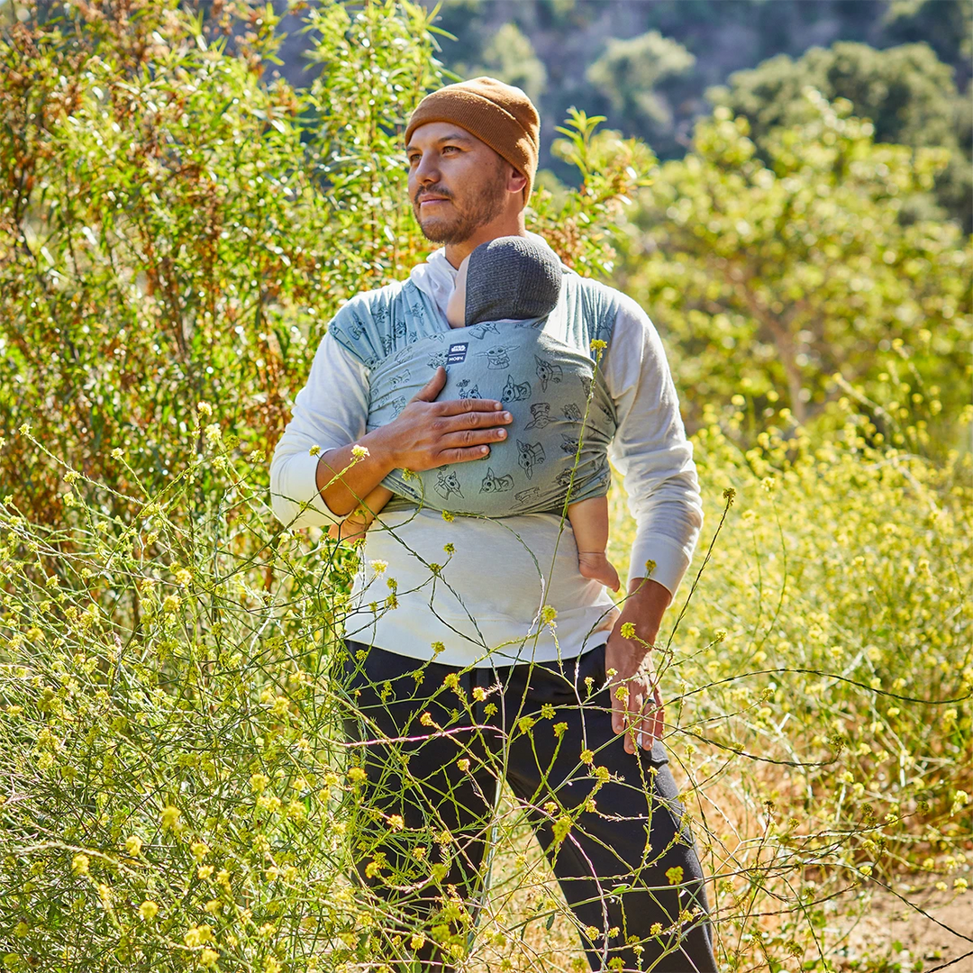 Dad wearing baby in Moby Featherknit Wrap in Playful Padawan