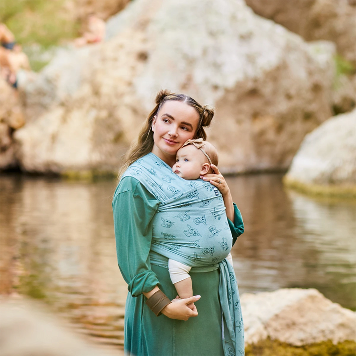 Mom wearing baby in Moby Featherknit Wrap in Playful Padawan