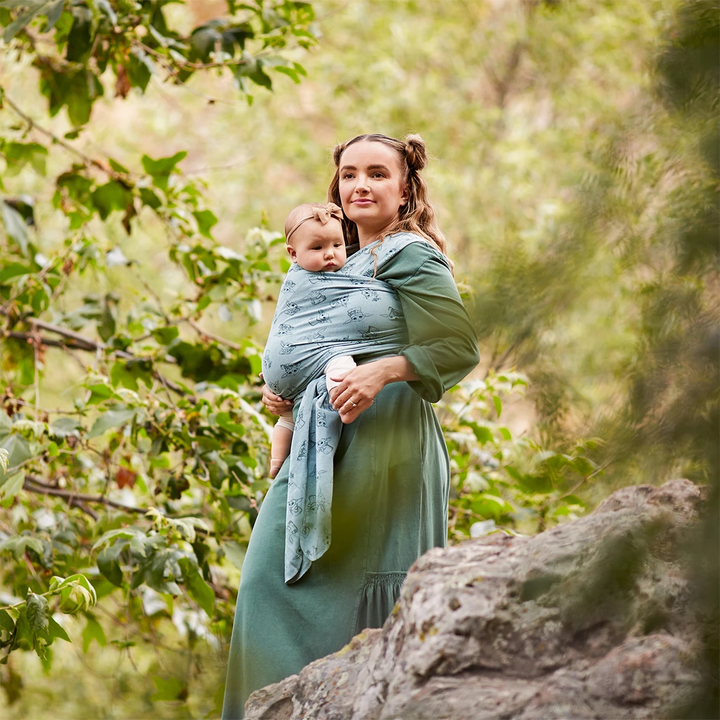 Mom wearing baby in Moby Featherknit Wrap in Playful Padawan