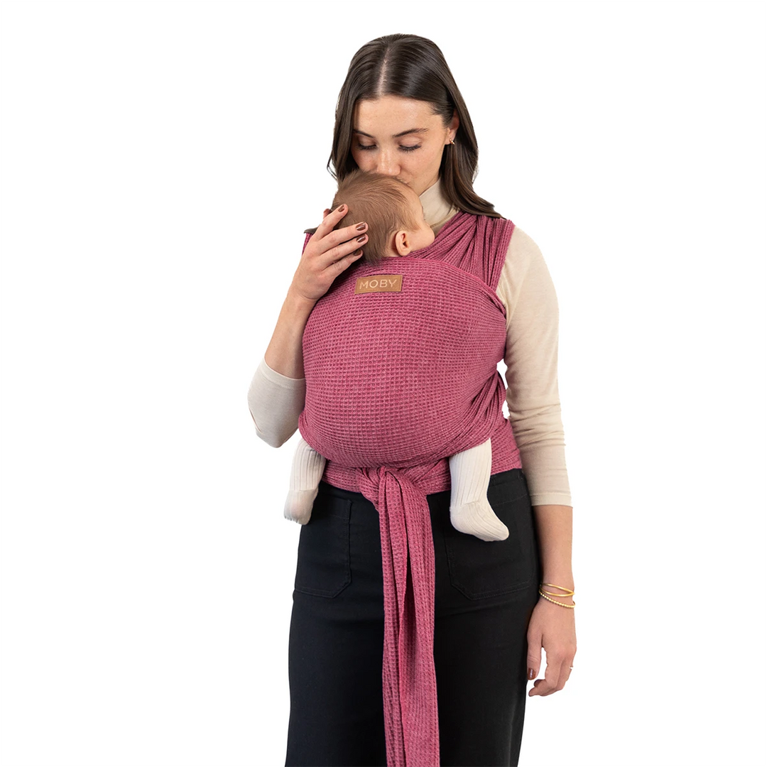 mom wearing baby in waffle knit wrap in desert rose