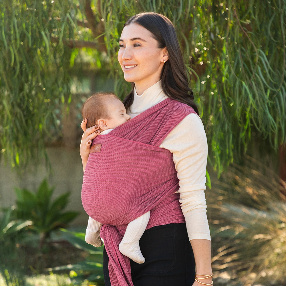 mom wearing baby in waffle knit wrap in desert rose