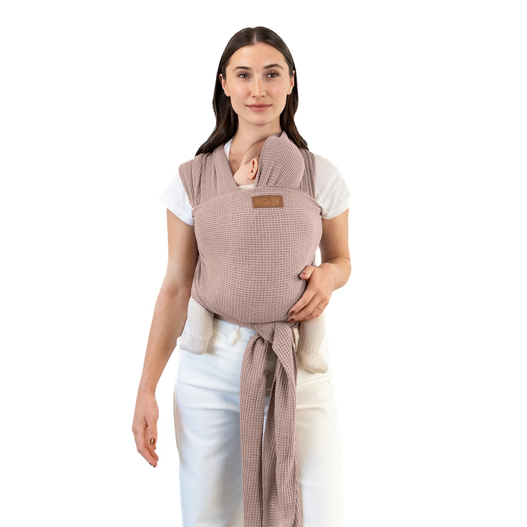 mom wearing baby in waffle knit wrap in sandstone