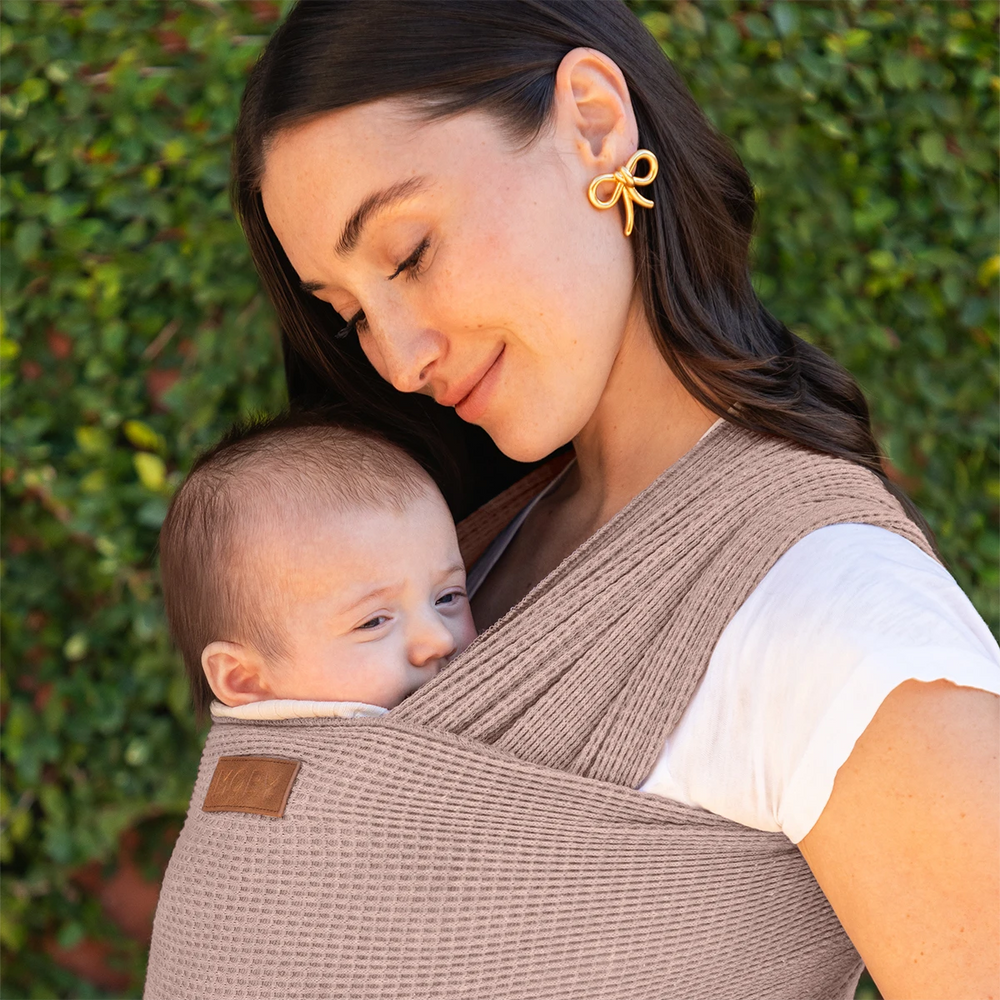 mom wearing baby in waffle knit wrap in sandstone