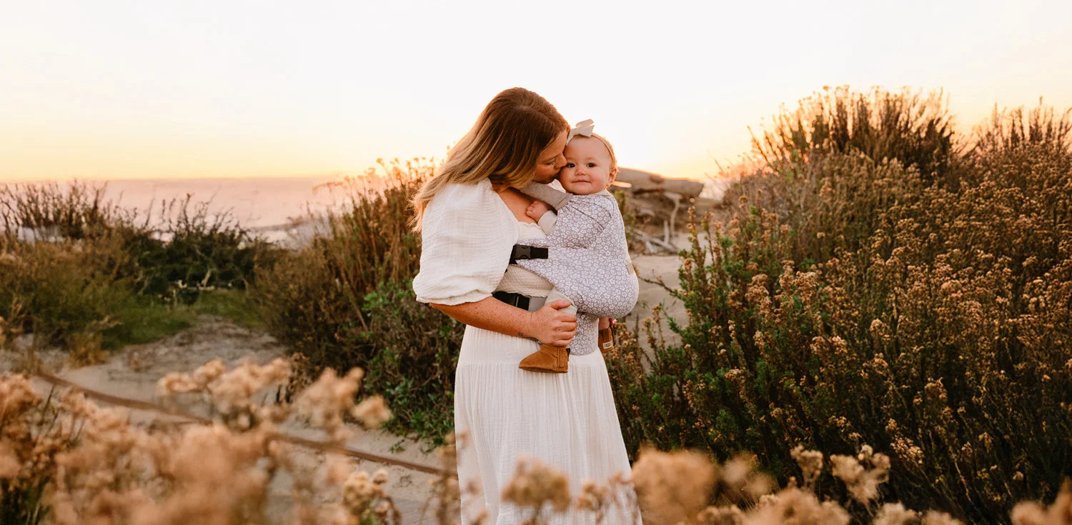 mom wearing baby in duet carrier in prairie blooms