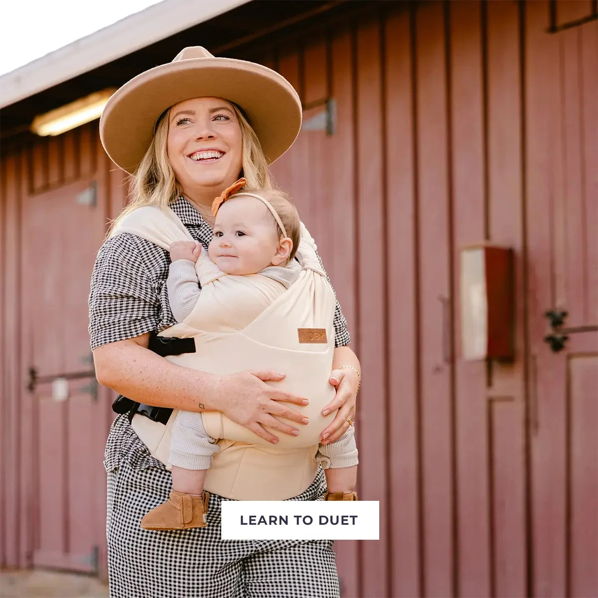 mom carrying baby in duet carrier in feather